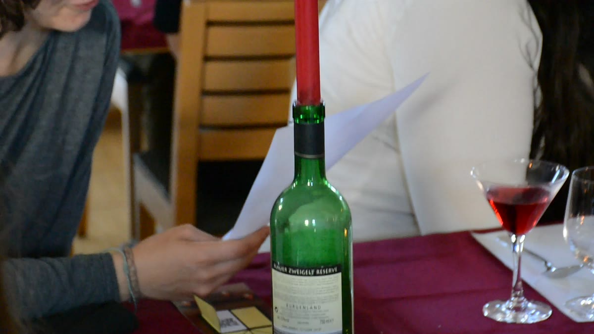 Weinflasche mit roter Kerze und rotem Cocktail